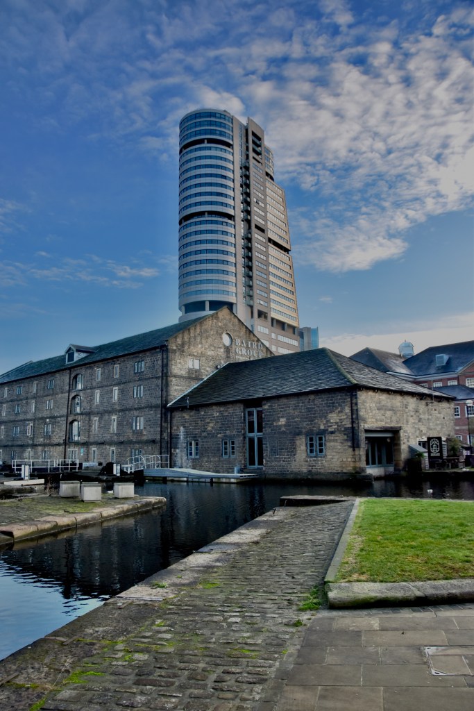 a view across canals in leeds, yorkshire, looking towards a tall tower